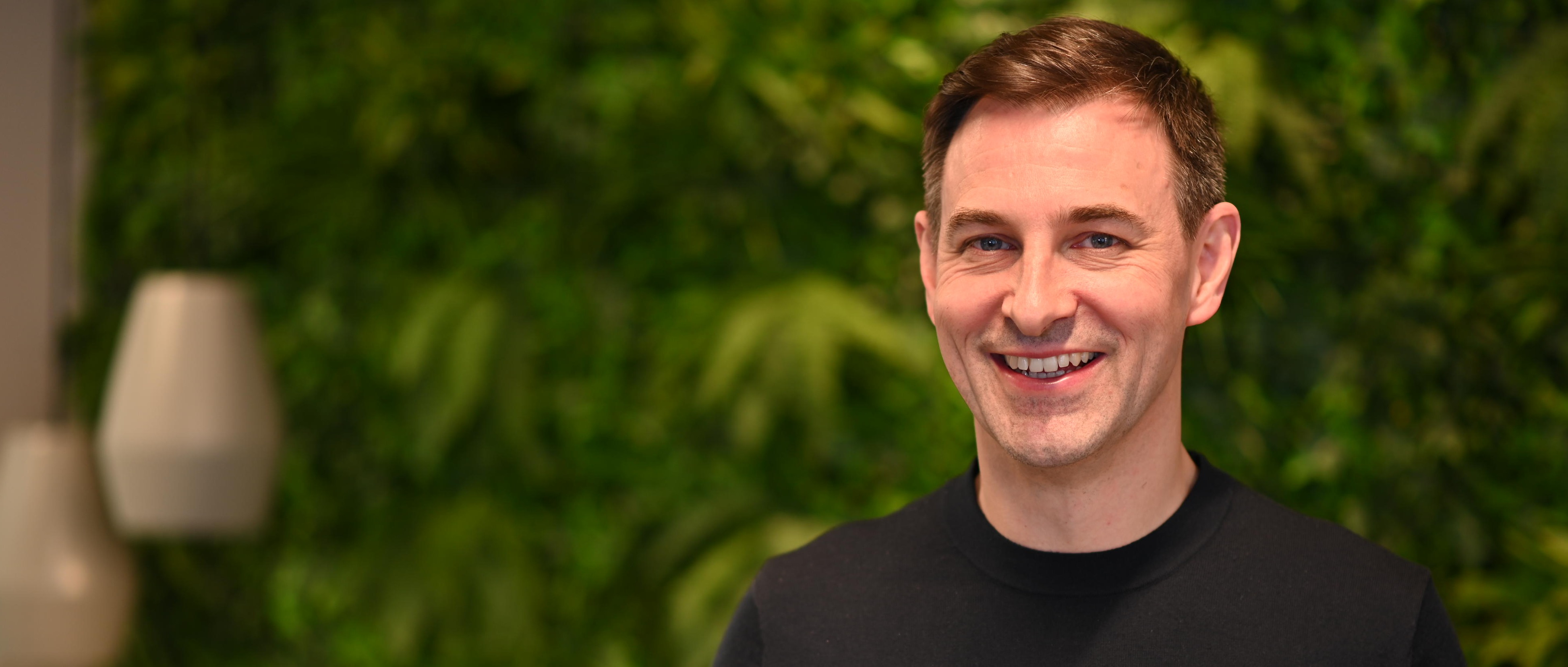 Lächelnder Mann in schwarzem Pullover