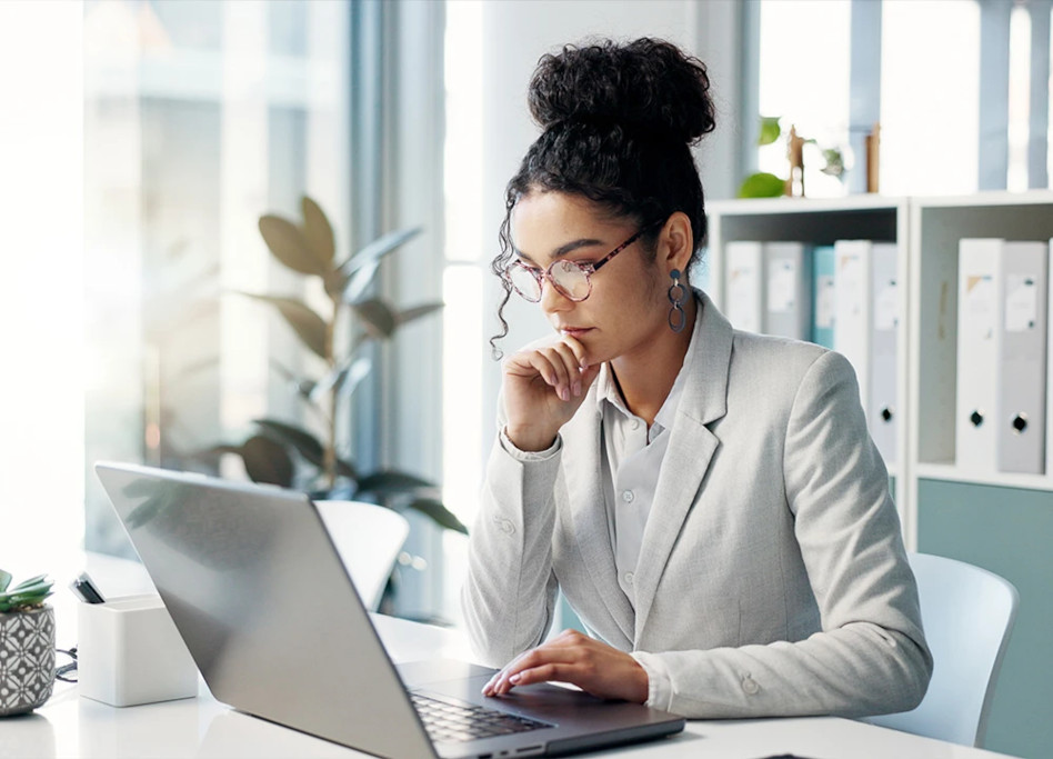Frau arbeitet konzentriert am Laptop.