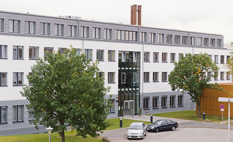 Modernes Gebäude mit Bäumen und Autos