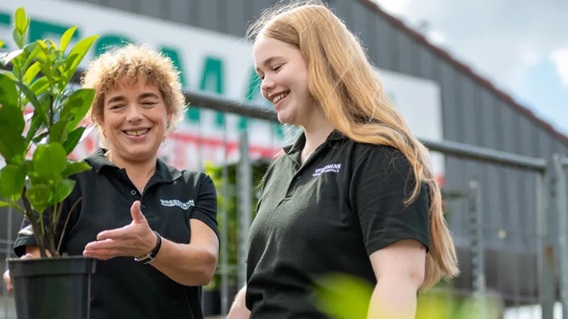 Mitarbeiterinnen mit Pflanze draußen