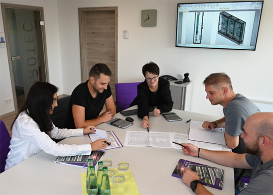 Fünf Personen diskutieren in einem Besprechungsraum