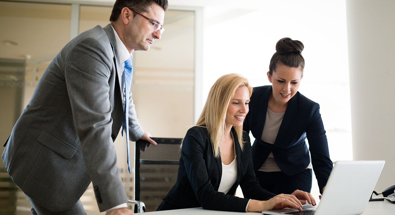 Drei Angestellte arbeiten zusammen.