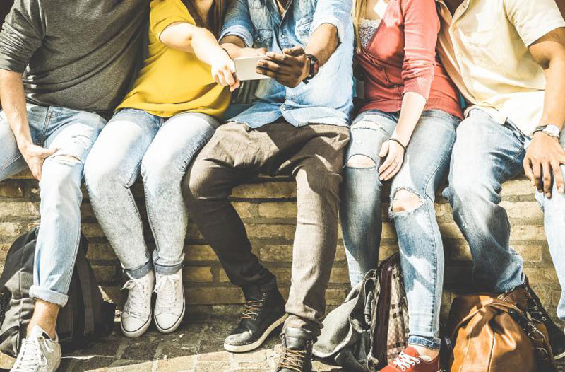 Eine Gruppe von Freunden schaut auf ein Telefon