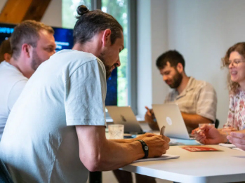 Mitarbeiter bei einer Besprechung mit Laptops und Notizen