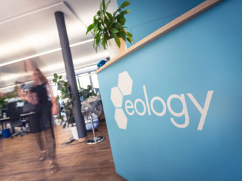Ein blauer Empfangstresen mit dem eology-Logo im hellen Büro
