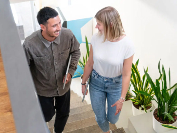 Zwei Kollegen unterhalten sich lachend im Treppenhaus