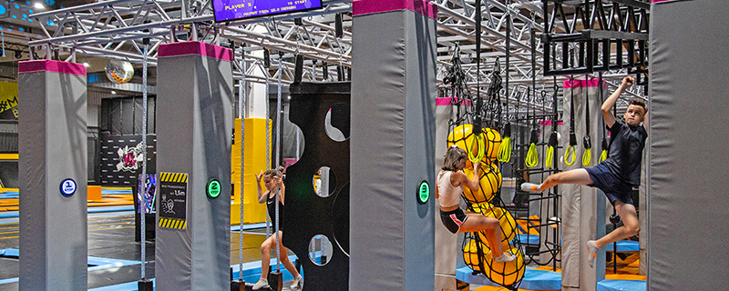 Kinder klettern auf einem Seilweg.