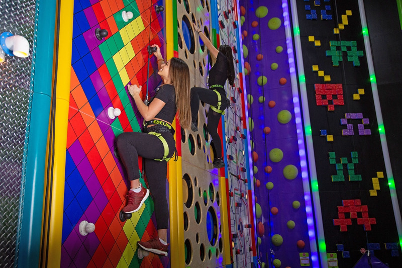 Zwei Frauen erklimmen eine Kletterwand