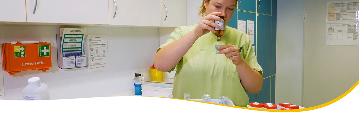 Pflegekraft in grüner Arbeitskleidung