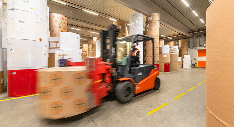 Gabelstapler transportiert große Papierrollen