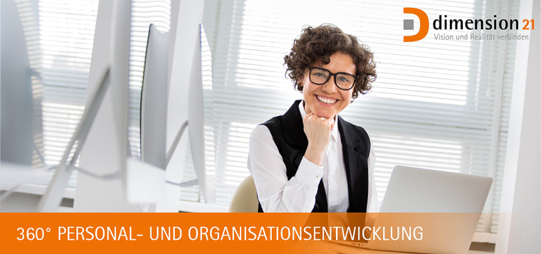 Frau mit Brille arbeitet am Laptop und lächelt