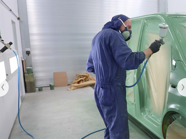 KFZ-Lackierer beim Lackieren eines Fahrzeugs