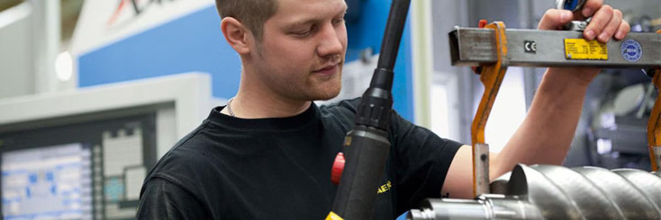 Mann arbeitet an Maschine.