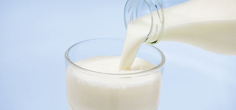 Milch in Glas gießen