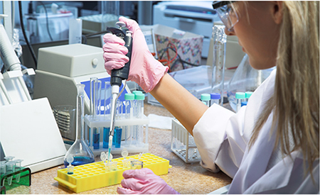 Laborantin bei der Arbeit mit Pipette