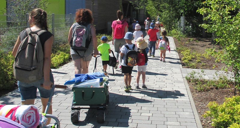 Eltern und Kinder gehen die Einfahrt hinunter