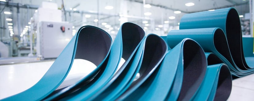 Blaue Förderbänder in moderner Produktionshalle