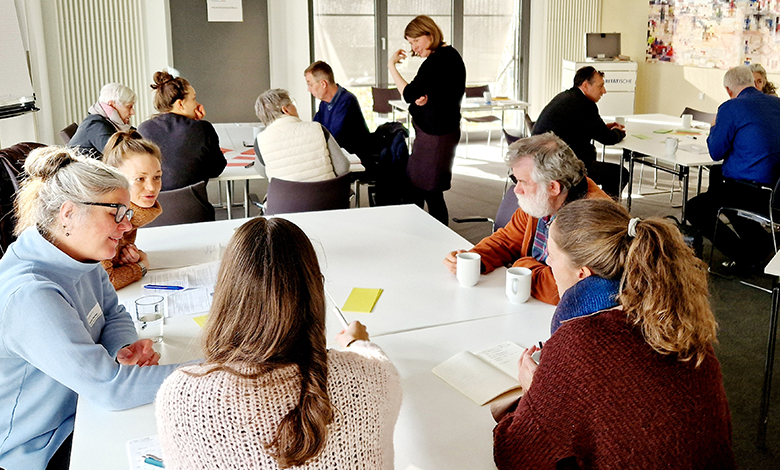 Gruppe diskutiert im Seminarraum