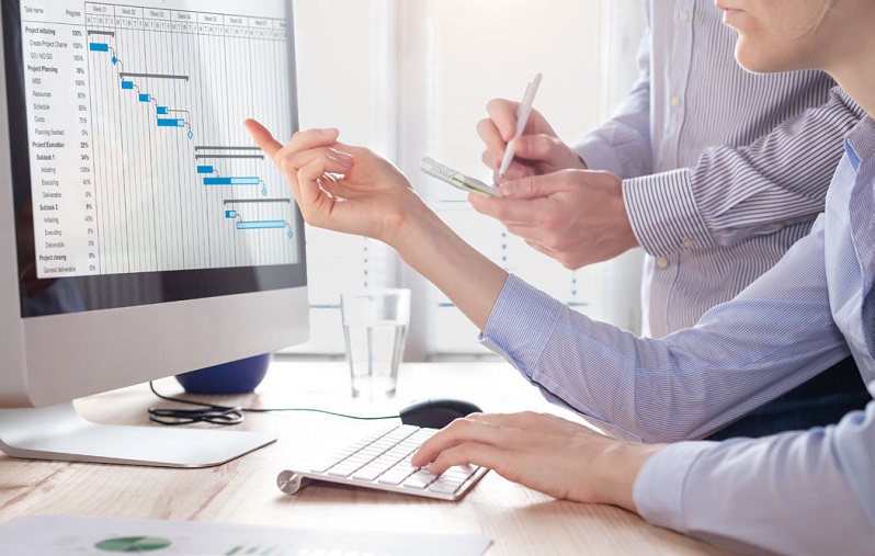 Zwei Angestellte bearbeiten Grafiken im Büro am Computer