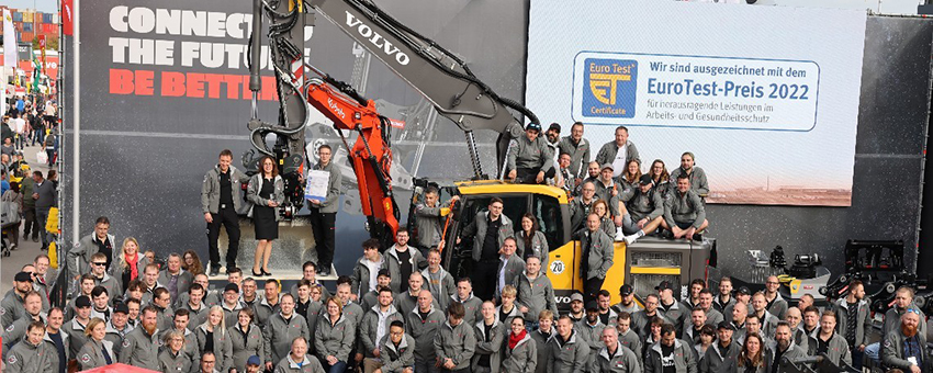 Teamfoto vor Volvo-Bagger