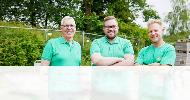 Drei Männer tragen blaue Hemden