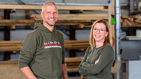 Mann und Frau lächeln in einer Holzwerkstatt
