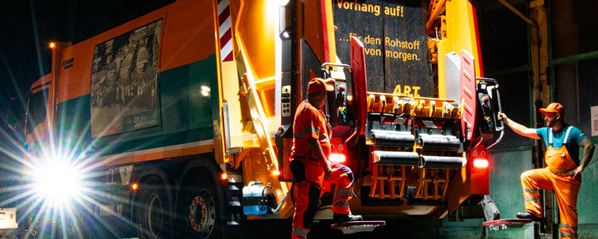 Mitarbeiter neben dem Müllwagen