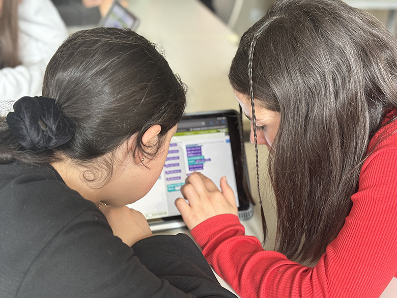 Zwei Mädchen programmieren gemeinsam an einem Tablet