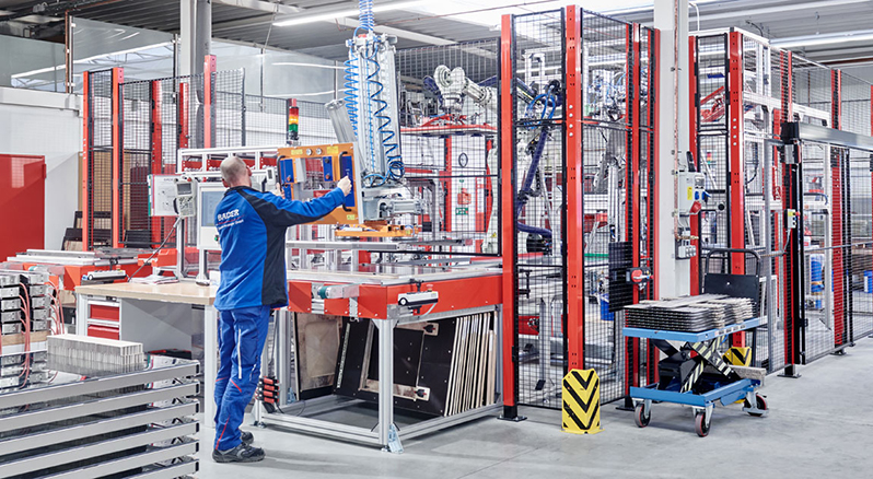 Mitarbeiter an automatisierter Fertigungsanlage in Werkhalle